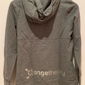 Orangetheory hoodie with side cutout, front pocket, and logo details.
